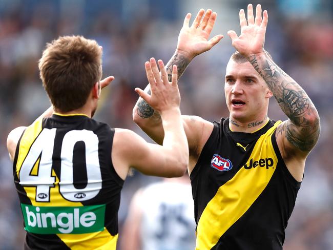 Newly re-signed Tiger Dustin Martin congratulates Dan Butler during the recent loss to Geelong.