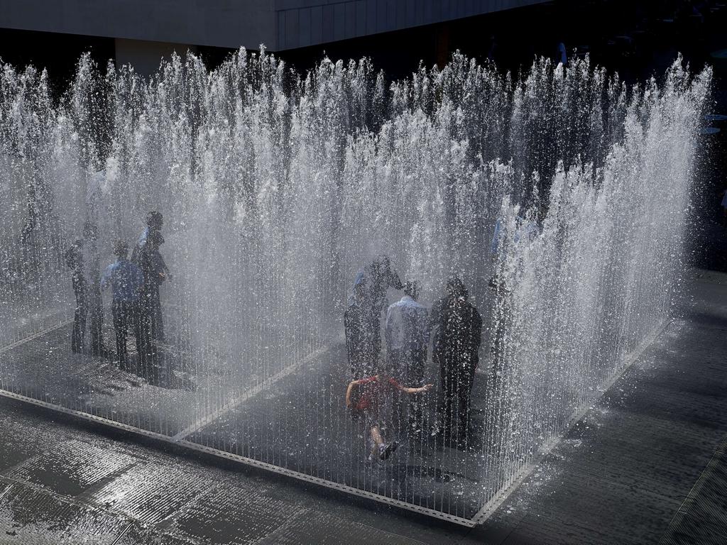 A group of teenagers play in a water fountain in central London on June 30, 2015. Picture: AFP