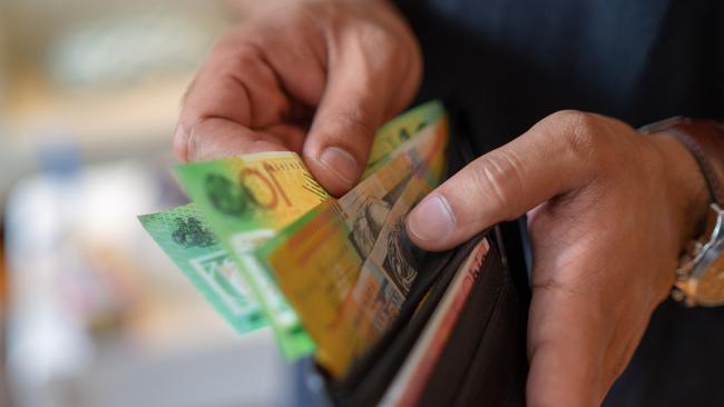 a male taking money out of a wallet, Australian cash generic spending