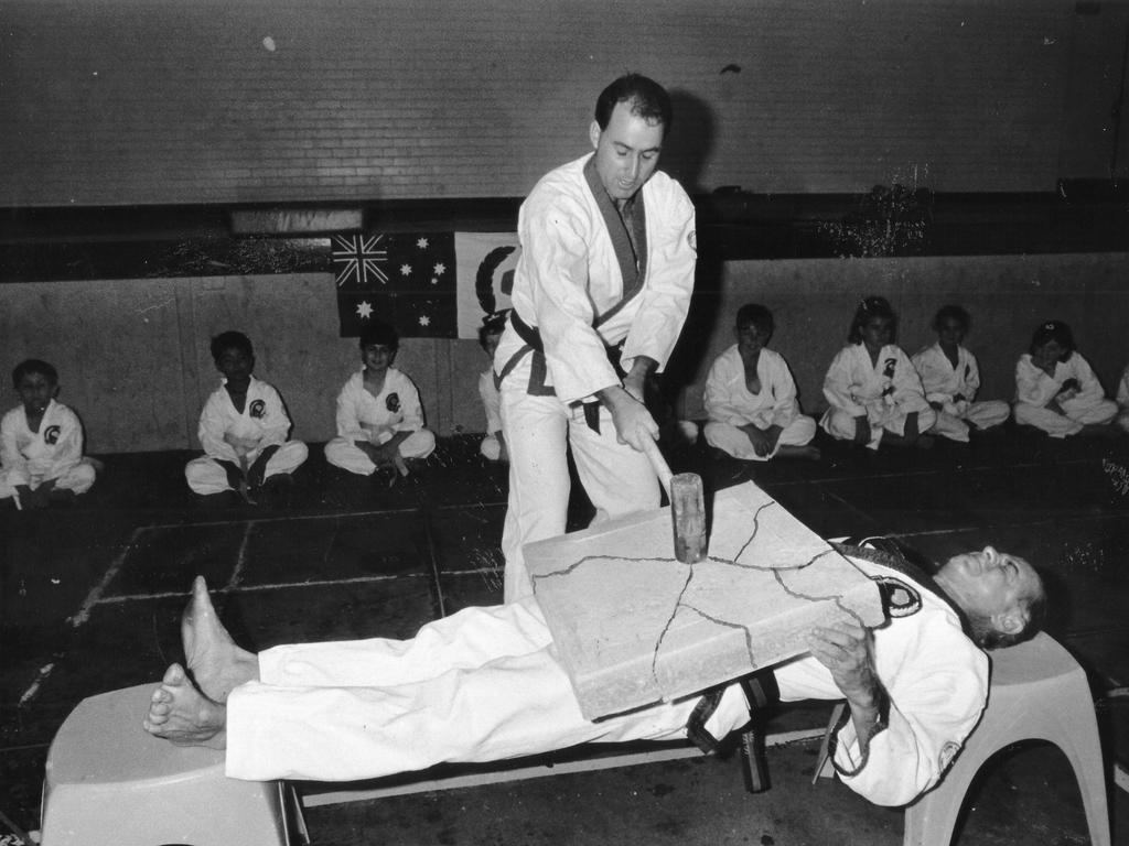 1992: Mike Austin wields a sledgehammer to smash the concrete block on father Chris, chief instructor at Darwin Karate Kai - Tang Soo Do