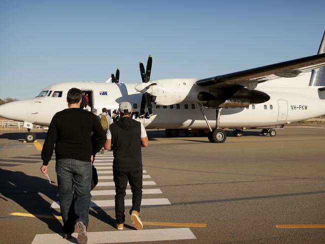 Fly In Fly Out (FIFO) workers make there way out to the Alliance airlines Fokker 50 at Olympic Dam in South Australia.