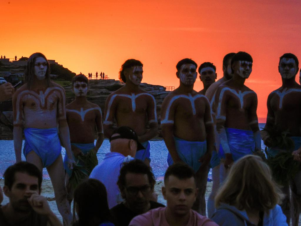 A group of La Perouse Gamay dancers looked on ahead of a performance at Bondi Beach for a Dawn Reflection and Smoking Ceremony on January 26, 2024. This year, supermarket chains Woolworths and Aldi announced they would stop stocking themed merchandise for the day, which drew political backlash from opposition leader Peter Dutton. Picture: Getty