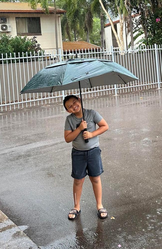 Nakara resident Rain Middleton plays in the rain during the first Darwin downpour of the 2023 wet season. Picture: Sunshine Middleton