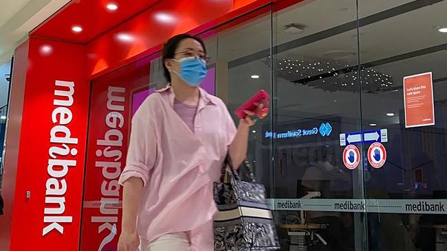 People walk past a shop front for Australia's largest health insurance company Medibank, in Sydney on November 11, 2022. - Russian hackers carried out a cyberattack on Medibank that breached the data of 9.7 million people, including the country's prime minister, police said 11 November. (Photo by Muhammad FAROOQ / AFP)