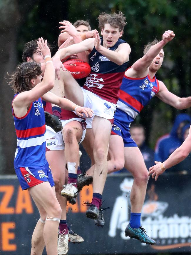 Sandhurst’s Cobi Maxted and Caleb Connick are sandwiched between two Gisborne opponents.