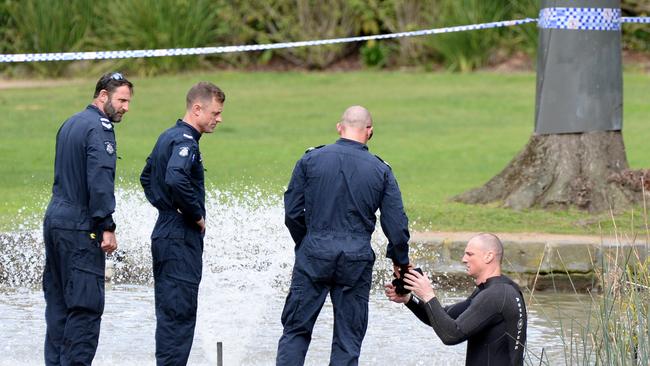 A police diver searches the fountain in Fitzroy Gardens. Picture: Andrew Henshaw