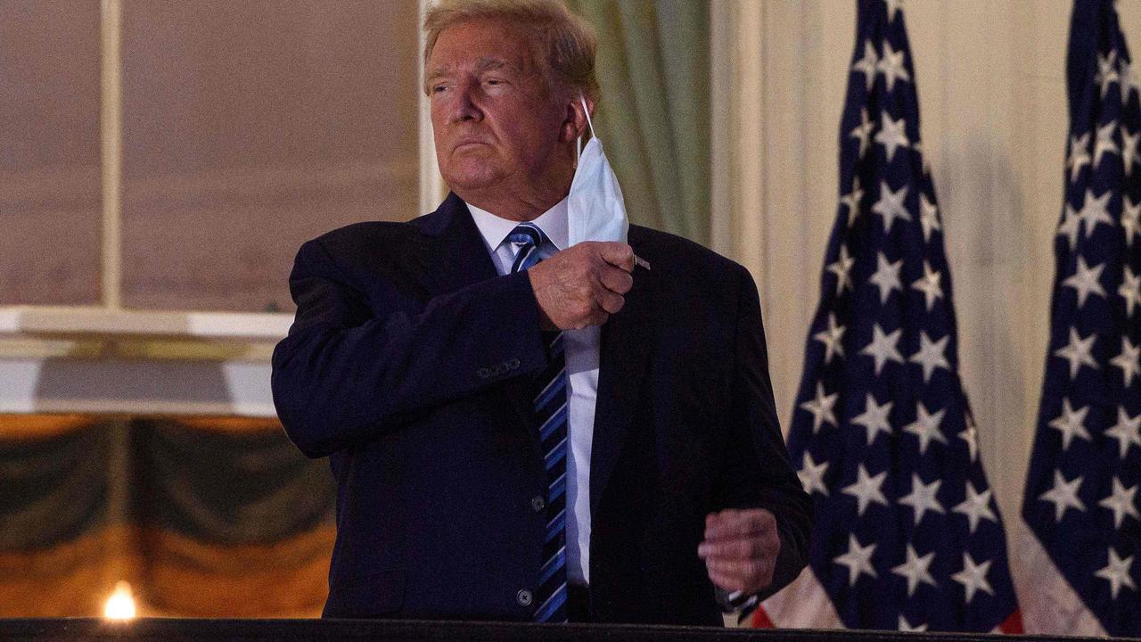 Donald Trump removing his mask before entering the White House. Picture: Nicholas Kamm/AFP