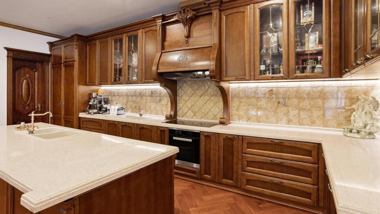 Fitted with timber cabinets and bevelled granite benchtops, the kitchen is equipped with a Liebherr integrated fridge, freezer and induction cooktop, butler’s pantry with a gas cooktop and walk-in pantry.