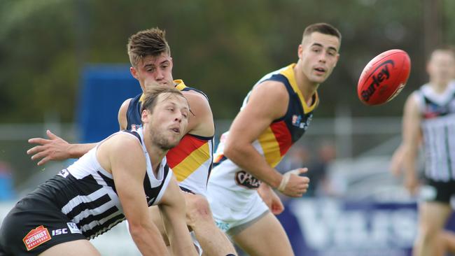 Port's SANFL captain Cameron Sutcliffe attempts to smother Adelaide's Riley Knight. Picture: AAP Image/Russell Millard