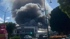 More than 40 firefighters and 12 fire trucks responded to the inferno inside a large commercial shed on Fitzroy Street, near Hockey Street, just after 4pm. Photo: Connor Perring.