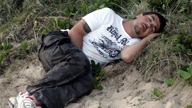 New Years partygoer sleeps it off at Mooloolaba Beach on New Year’s Day in 2007. Picture: David Thomas