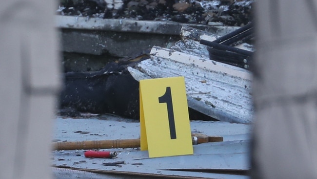 Police and firefighters gather evidence at the scene. Picture: John Grainger