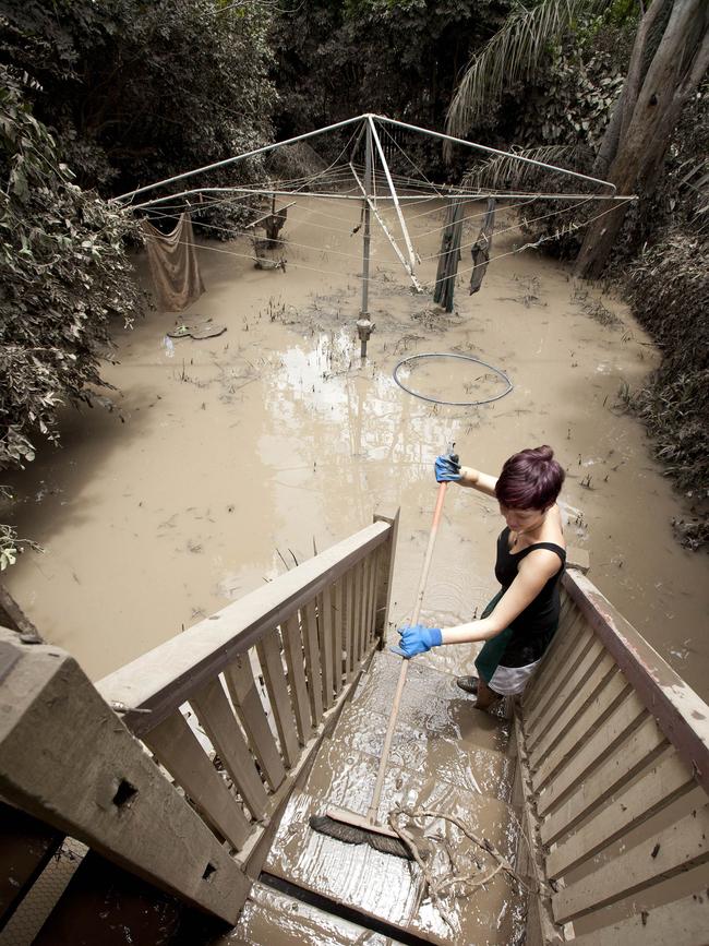 In a file picture taken on January 14, 2011 Alice Richter-Ward cleans the mud from her Ryan Street home in the West End area of Brisbane after floodwaters inundated many parts of the city.