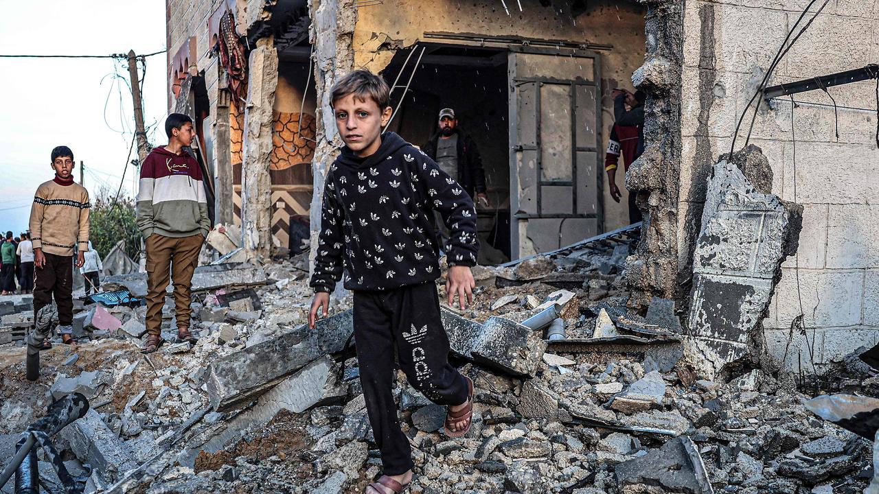 Children walk through the rubble of a building heavily damaged by Israeli bombardment in Rafah. Picture: AFP