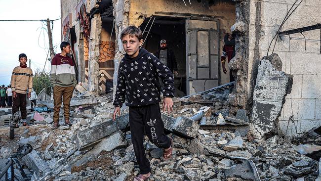 Children walk through the rubble of a building heavily damaged by Israeli bombardment in Rafah. Picture: AFP