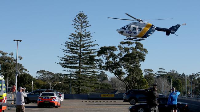 Emergency services and the CareFlight helicopter on the roof top of Forest Way shopping centre after treating a person who was hit by a car on Forest Way, Frenchs Forest. Picture by Damian Shaw