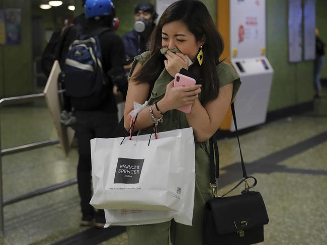 A woman reacts from tear gas inside a MTR station as protesters face off with riot police. Picture: AP