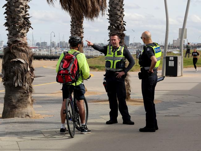 Police patrol the St Kilda Beach foreshore after the beach was closed and new social distancing rules put in place. Picture: David Geraghty