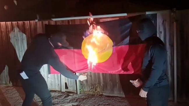 Masked men set fire to the Aboriginal flag after reading out a sick, racist statement.