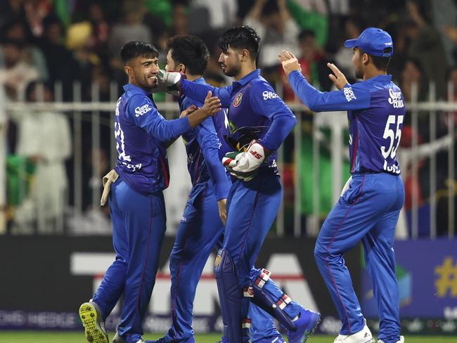 SHARJAH, UNITED ARAB EMIRATES - MARCH 18: Nangeyalia Kharote of Afghanistan celebratesCurtis Champer of Ireland  with teammates after dismissing  during the Men's Twenty20 International match between Afghanistan and Ireland on March 18, 2024 in Sharjah, United Arab Emirates. (Photo by Francois Nel/Getty Images)