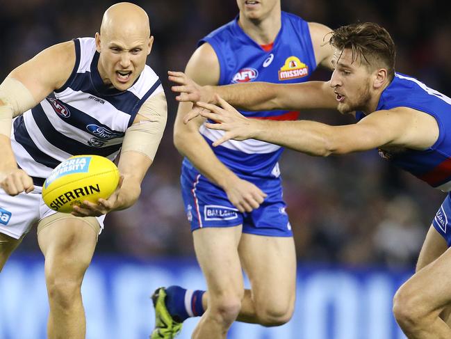 AFL Round 15. 29/06/2018. Western Bulldogs v Geelong at Etihad Stadium.  Geelong's Gary Ablett clears by hand infant of Western Bulldogs Marcus Bontempelli   . Pic: Michael Klein