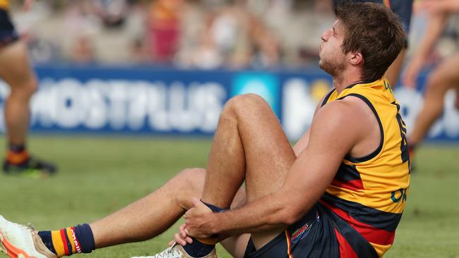 Crows defender Jordon Butts clutches his ankle.