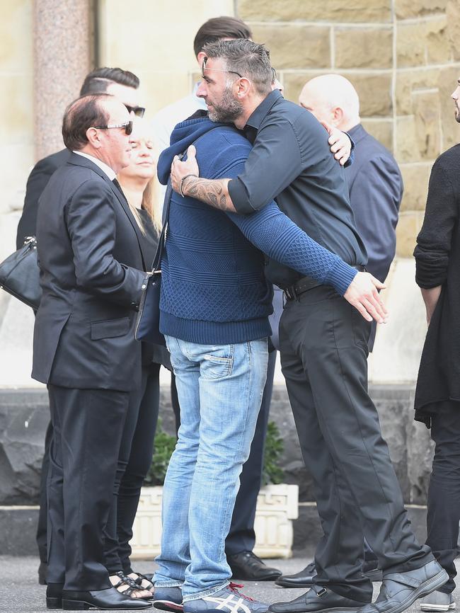 Mourners embrace at St. Mary's Star of the Sea in West Melbourne. Picture: Jake Nowakowski