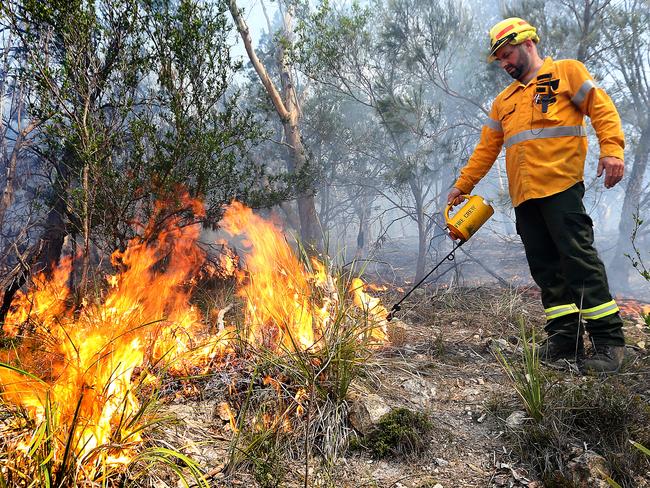 Parks and Wildlife fire crew supervisor James Shaw starts fires during a controlled burn on Crown Land at Risdon Vale