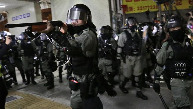 A police officers points his shot un at protesters. Picture: AP