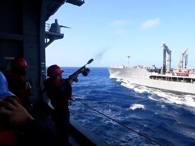 In this still from a video, a sailor from the USS America shoots a line from a modified M-14 rifle over to the HMAS Ballarat earlier this week to prepare for a replenishment at sea, or to refuel the Ballarat during Exercise Talisman Sabre 2021. Picture: Supplied