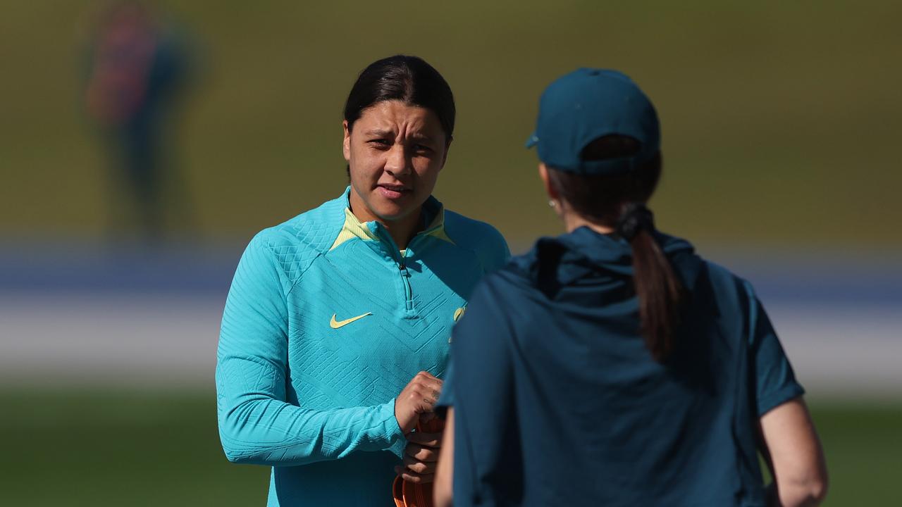 Sam Kerr (left) chats with a Matildas staff member at training on Sunday. Picture: Chris Hyde/Getty Images