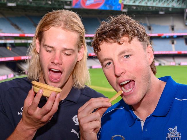 MELBOURNE, AUSTRALIA - FEBRUARY 19: Carlton young gun Tom De Koning and North Melbourne's Nick Larkey tuck into food at Marvel Stadium (Photo by Jordan Sacchetta/AFL Photos)