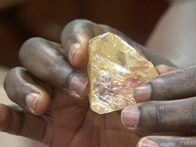 In this photo taken from video footage, Sierra Leone's President Ernest Bai Koroma hands a diamond during a meeting with delegates of Kono district, where the gem was found, at the presidential office in Freetown, Sierra Leone, Thursday, March 16, 2017. A pastor in Sierra Leone has discovered the largest uncut diamond found in more than four decades in this West African country and has turned it over to the government, saying he hopes it helps to boost recent development in his impoverished nation. (SLBC via AP)