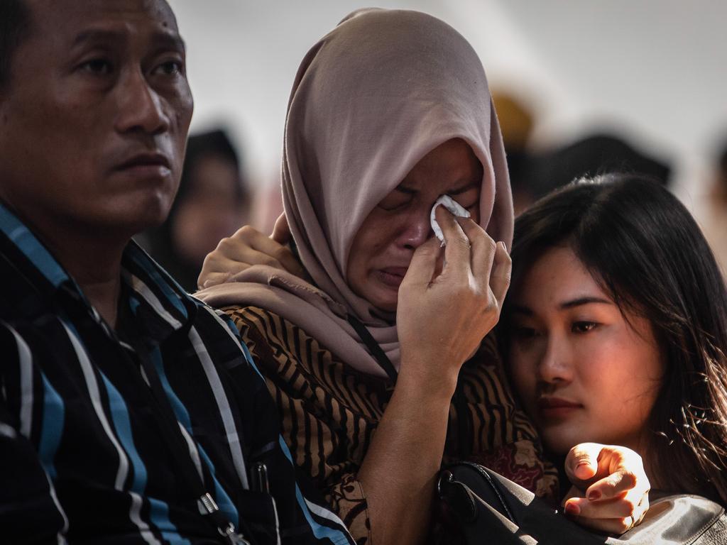 Families and colleagues of victims of Lion Air flight JT 610 cry on deck of Indonesian Navy ship KRI Banjarmasin. Picture: Getty