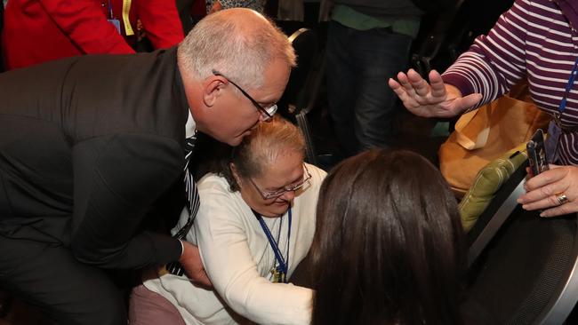 The Prime Minister helps up a woman who was knocked over after an egg was thrown at him. Picture: Alex Coppel