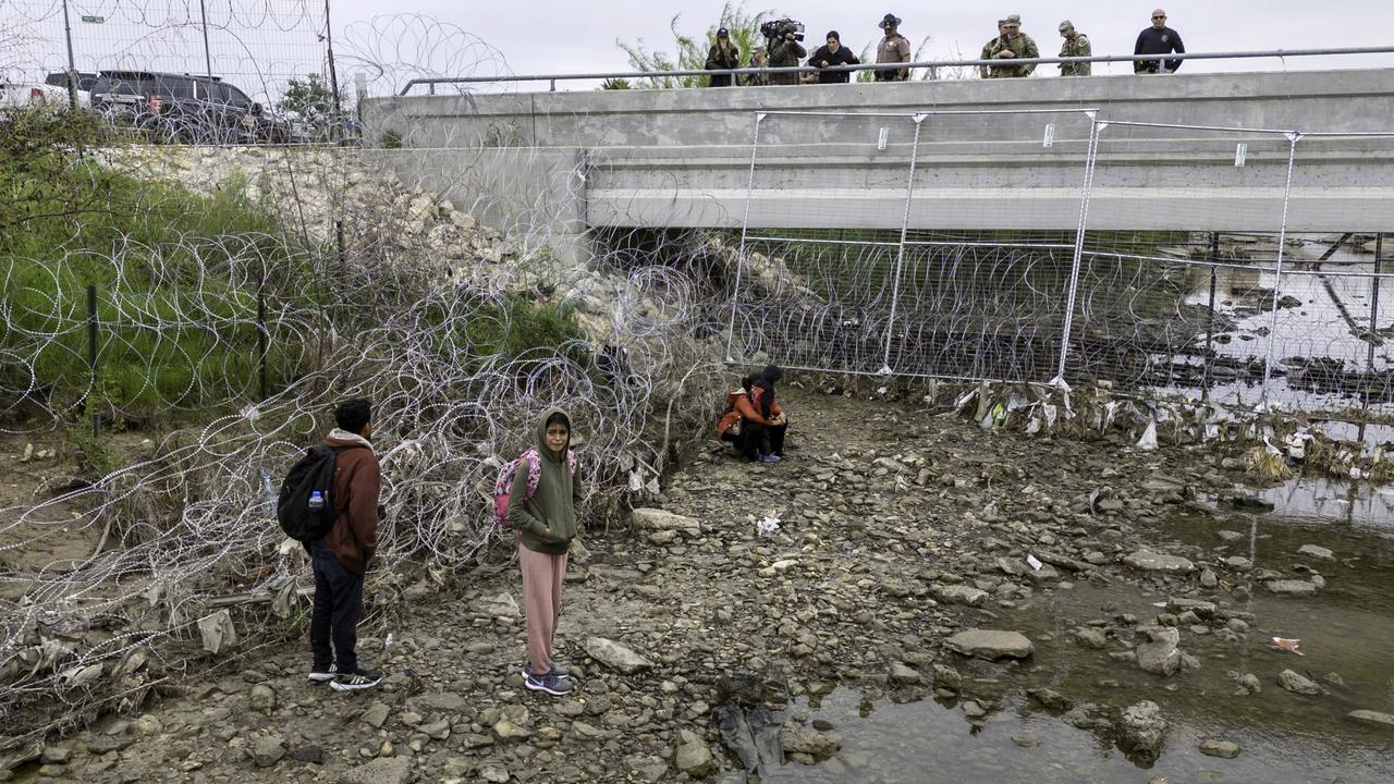 U.S. soldiers and law enforcement oversee immigrants by the Rio Grande in Eagle Pass, Texas, amid “Operation Lone Star” fortifications to deter crossings. Picture: John Moore/Getty Images