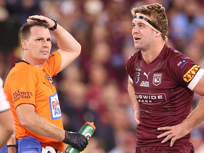 TOWNSVILLE, AUSTRALIA - JUNE 09:  Christian Welch of the Maroons is attended to by a team trainer after a tackle during game one of the 2021 State of Origin series between the New South Wales Blues and the Queensland Maroons at Queensland Country Bank Stadium on June 09, 2021 in Townsville, Australia. (Photo by Mark Kolbe/Getty Images)