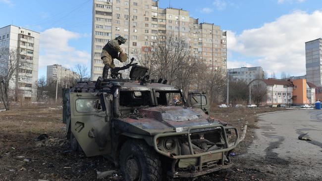 An Ukrainian Territorial Defence fighter examines a destroyed Russian infantry mobility vehicle GAZ Tigr after the fight in Kharkiv on February 27. Picture: AFP