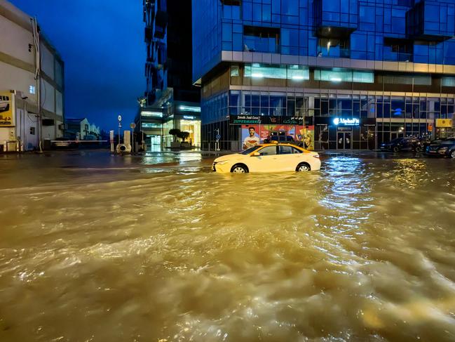 A taxi drives through a flooded street following heavy rains in Dubai. Picture: AFP