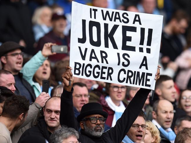 A fan holds a sign criticising VAR ahead of the English Premier League football match between Manchester City and Wolverhampton Wanderers at the Etihad Stadium in Manchester, north west England, on October 6, 2019. (Photo by Oli SCARFF / AFP) / RESTRICTED TO EDITORIAL USE. No use with unauthorized audio, video, data, fixture lists, club/league logos or 'live' services. Online in-match use limited to 120 images. An additional 40 images may be used in extra time. No video emulation. Social media in-match use limited to 120 images. An additional 40 images may be used in extra time. No use in betting publications, games or single club/league/player publications. /