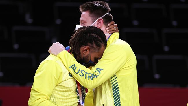 Patty Mills and teammate Matthew Delavedova hug it out.