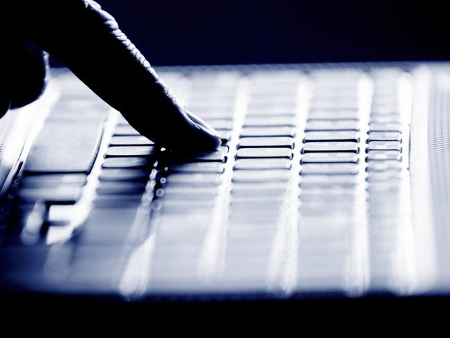 Concept photo in high contrast black and white of hacker's single finger on keyboard