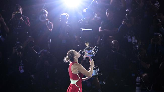 Aryna Sabalenka poses with the Daphne Akhurst Memorial Cup after victory against Zheng Qinwen during their women's singles final. Picture: Anthony Wallace/AFP)