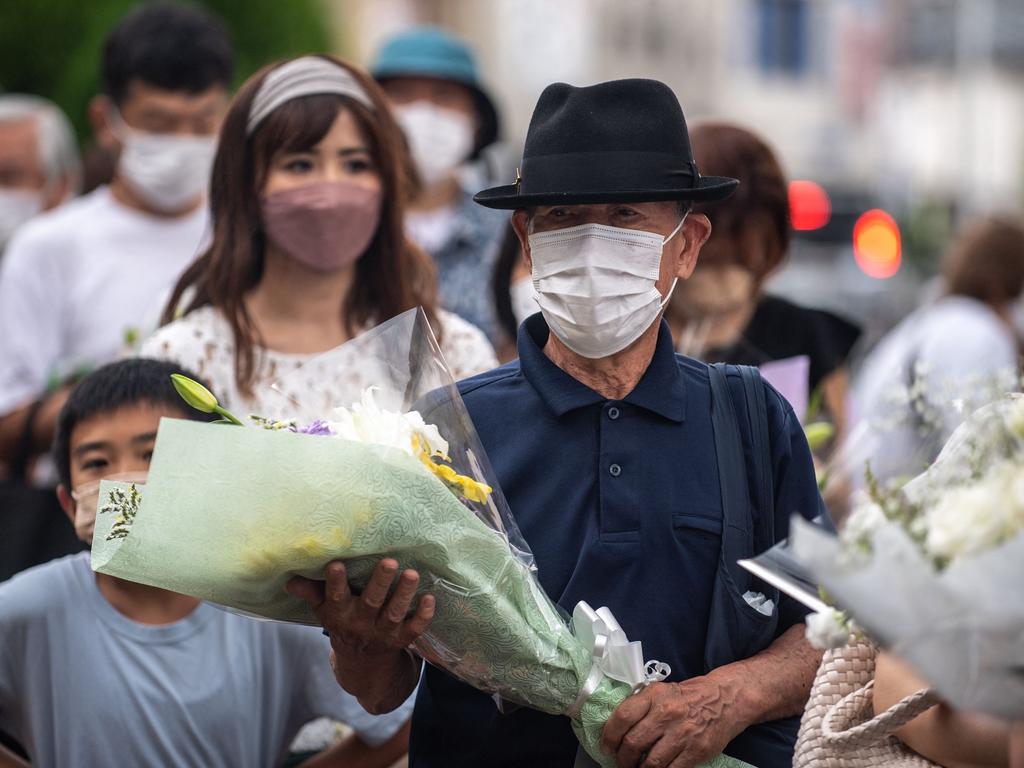 People line up to place flowers at a makeshift memorial outside Yamato-Saidaiji Station, where former Japanese prime minister Shinzo Abe was shot on July 8. Picture: Philip Fomg / AFP