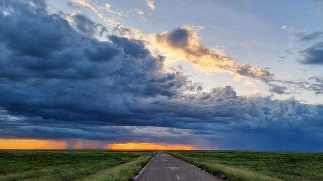 A storm gathers in the distance as sunset illuminates the rain showers. Picture: Jordyn Ballantine