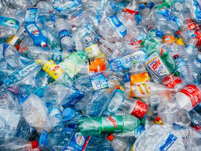 Stack of crushed colorful plastic bottles background waiting for recycling.