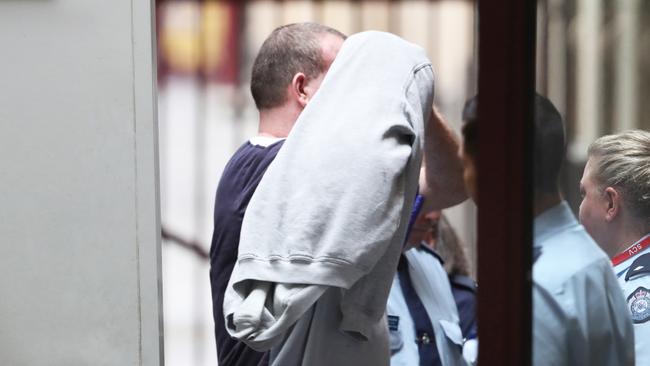 Scott Murdoch covers his face as he is taken into the Victorian Supreme Court in 2020. Picture: AAP Image/David Crosling.