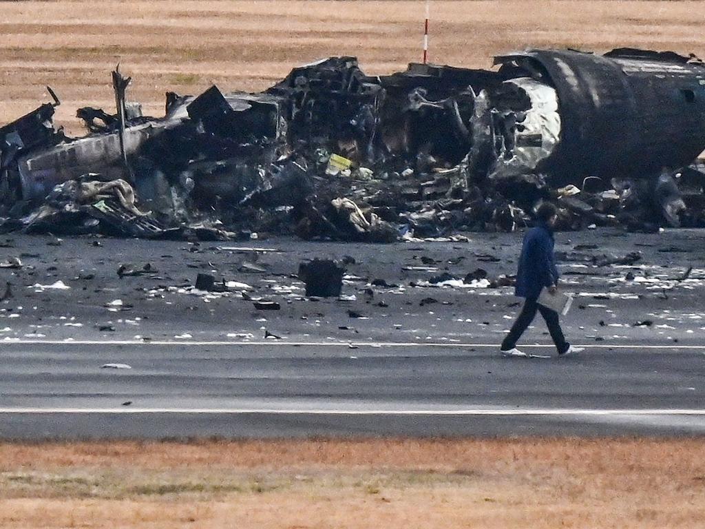 An official looks at the wreckage of a Japan Coast Guard plane. Picture: AFP