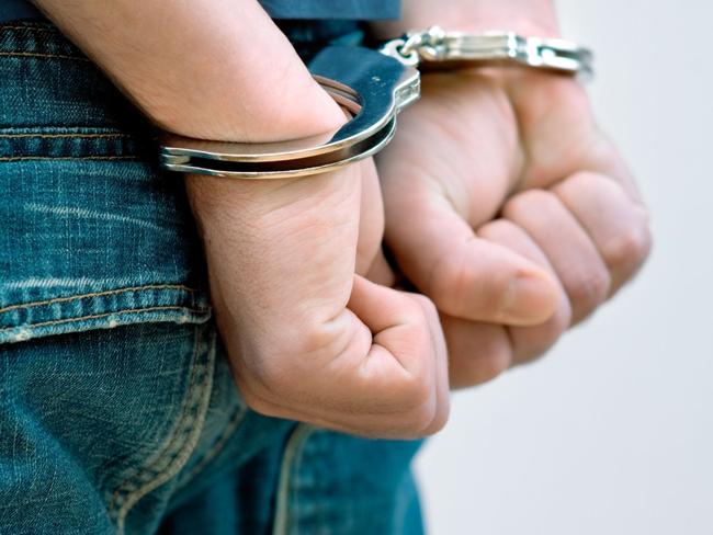 Generic Thinkstock image of youth crime - hand cuffs teenager under arrest.