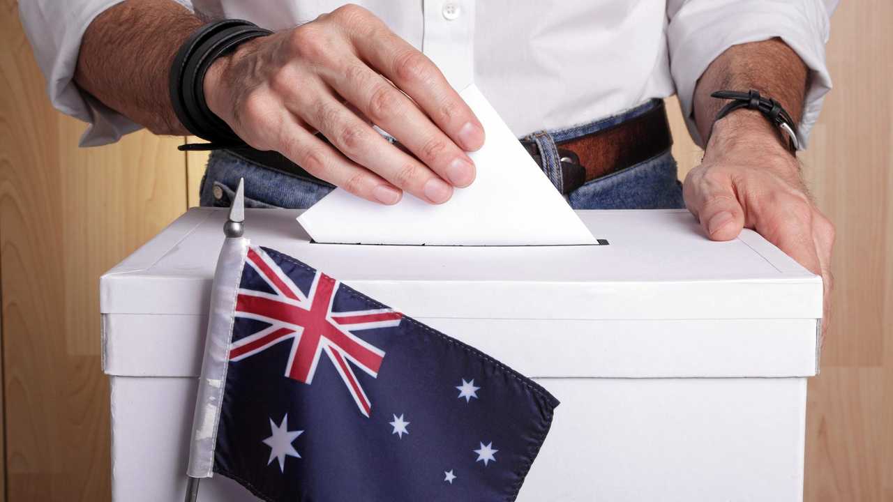 A man inserting a ballot to a ballot box.  Australian flag in front of it. Picture: iStock